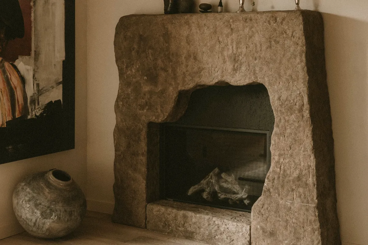 Whole-home remodel by Apex Builders: sculpted stone fireplace with wide-plank oak floors